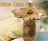Wooden wine glass holder with scalloped edges and round pegs securing glasses on a bottle neck
