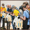 Youth using wood lathes under instructor supervision during woodworking workshop session