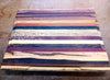 Multi-wood cutting board with routed juice groove along the edges on a workbench