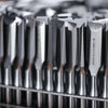 Close-up of precision-ground Pfeil carving gouges with beveled edges in a rack, one marked Swiss Made