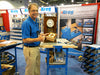 Man holding a small wooden box with fleur-de-lis inlay at a Kreg woodworking tools booth