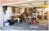 Garage workshop with workbenches, hand tools on pegboards, power tools, and woodworking supplies before makeover