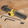 Set of ball-end hex keys with yellow plastic holder on wooden workbench surface