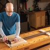 Woodworker using a 3-in-1 shooting board to trim and square a wooden board edge