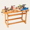 Workbench with hand tools, clamps, cordless drills, a vise, and woodworking accessories arranged on top