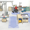 Wheelchair user operating a lathe in an accessible woodworking shop with dust collection system and workbenches.